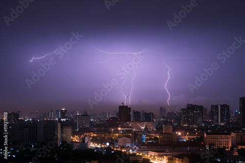 Lightning storm over city in purple light