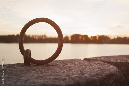 mooring ring on river bank for boats in sunset
