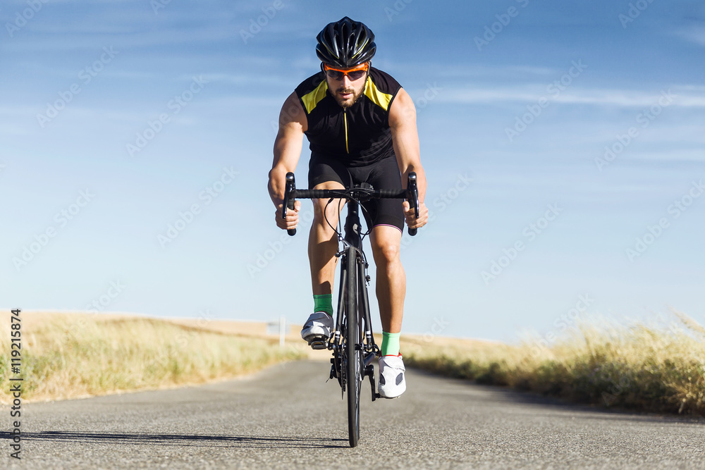 Obraz premium Handsome young man cycling on the road.