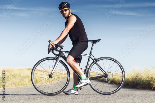 Handsome young man cycling on the road.