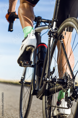 Close-up of the foot of a young man cycling.