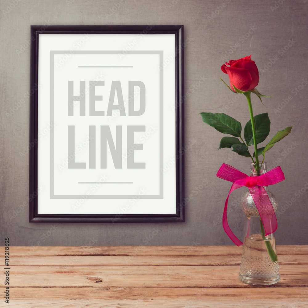 Poster mock up template with rose flower in vase on wooden table - obrazy, fototapety, plakaty 