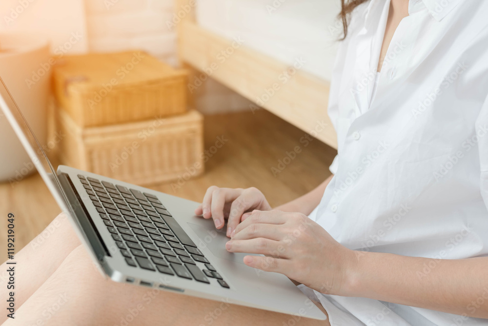 Fototapeta premium Woman Using Laptop In Bedroom by the window