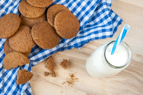 Fototapeta Naklejka Na Ścianę i Meble -  Milk bottle with straw and oatmeal cookies on wooden table