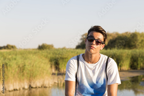 young man looking at camera with serious gesture in nature