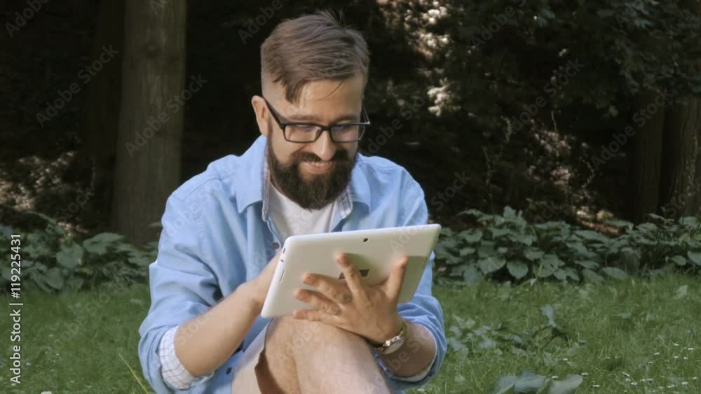 handsome man surfing on tablet and smile handsome man surfing on tablet and smile