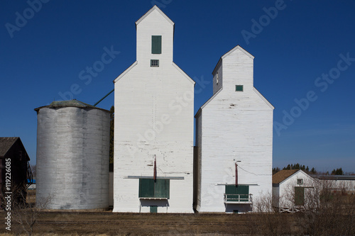 Tall industrial wooden grain elevators beside a railroad photo