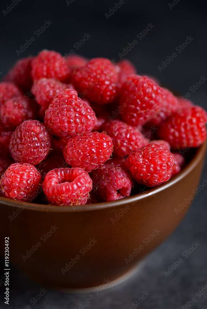 Fresh, juicy raspberries in a bowl on a black background Fresh, juicy raspberries in a bowl on a black background