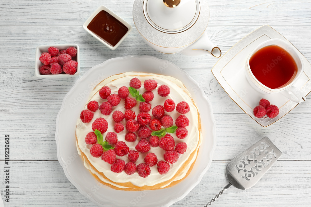 Tasty raspberry cake with fresh tea on wooden background Tasty raspberry cake with fresh tea on wooden background