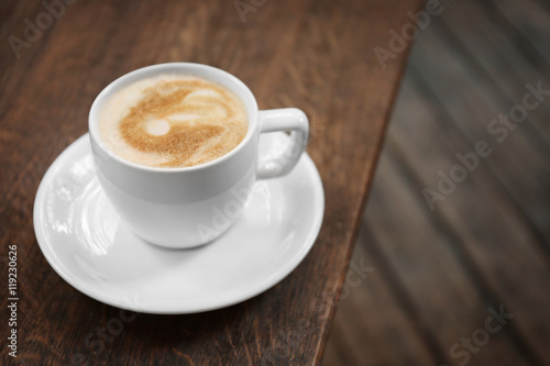 Cup of fresh coffee on wooden table
