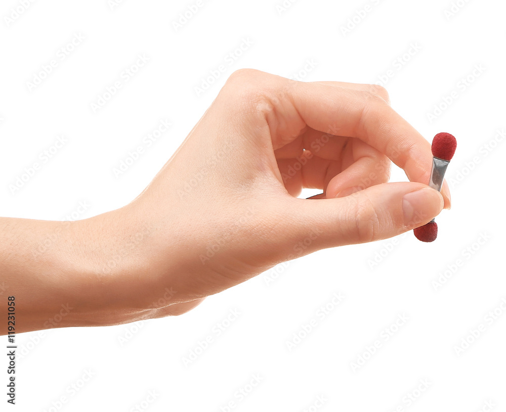 Female hand holding small brush Female hand holding small brush