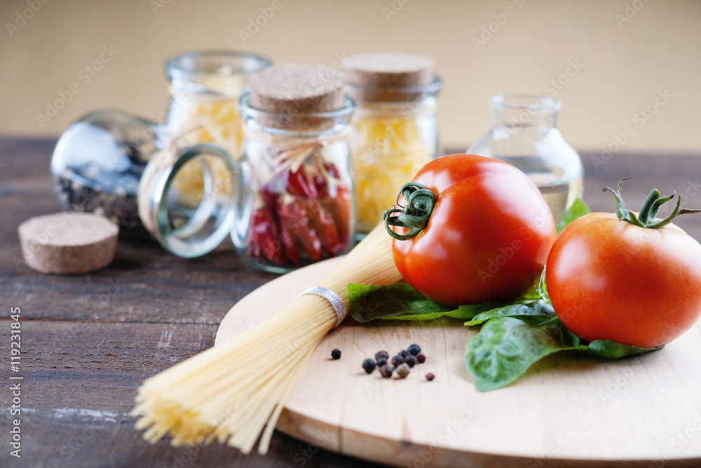Red tomatoes on a cutting board and pasta Red tomatoes on a cutting board and pasta