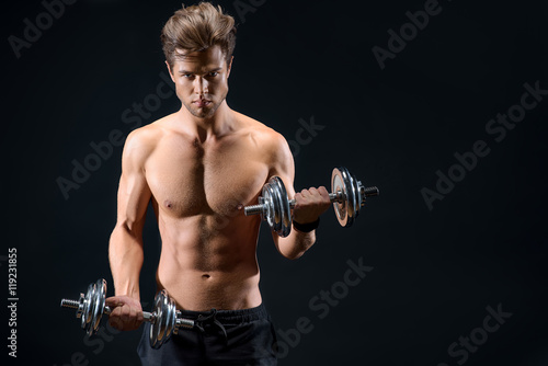 Confident male athlete exercising with weights