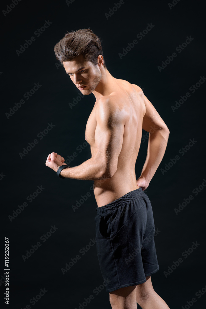 Cheerful young man showing his bicep Cheerful young man showing his bicep