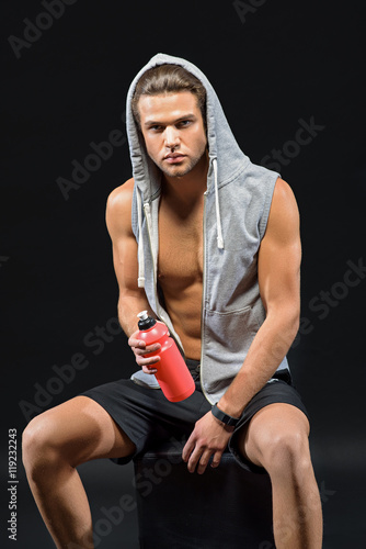 Confident male athlete relaxing after workout