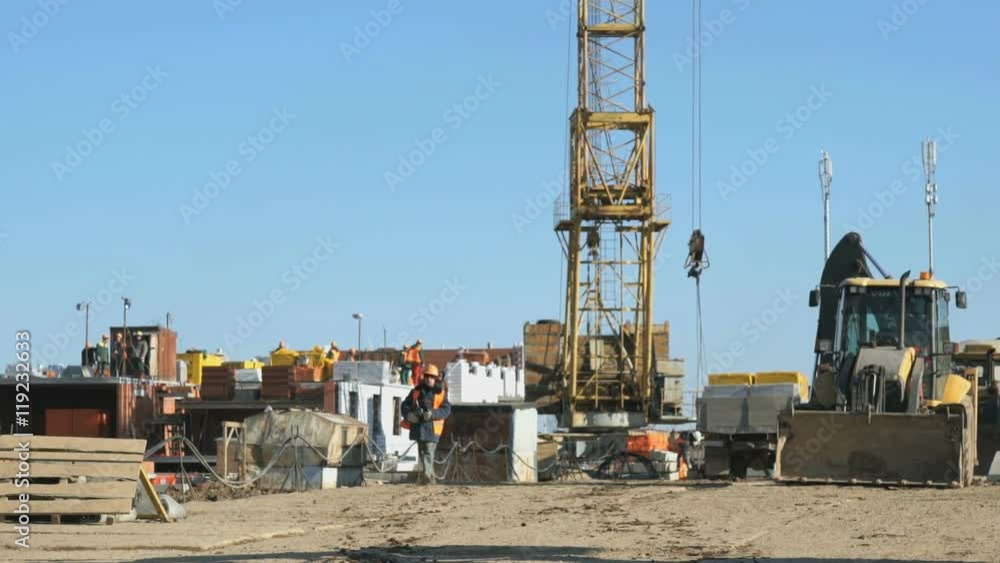 Builder goes to the background construction site Builder goes to the background construction site