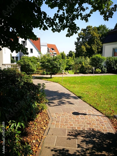 Gepflasteter Gartenweg in einem parkähnlichen Garten im Sommer bei Sonnenschein in Oerlinghausen bei Bielefeld am Hermannsweg im Teutoburger Wald in Ostwestfalen-Lippe photo