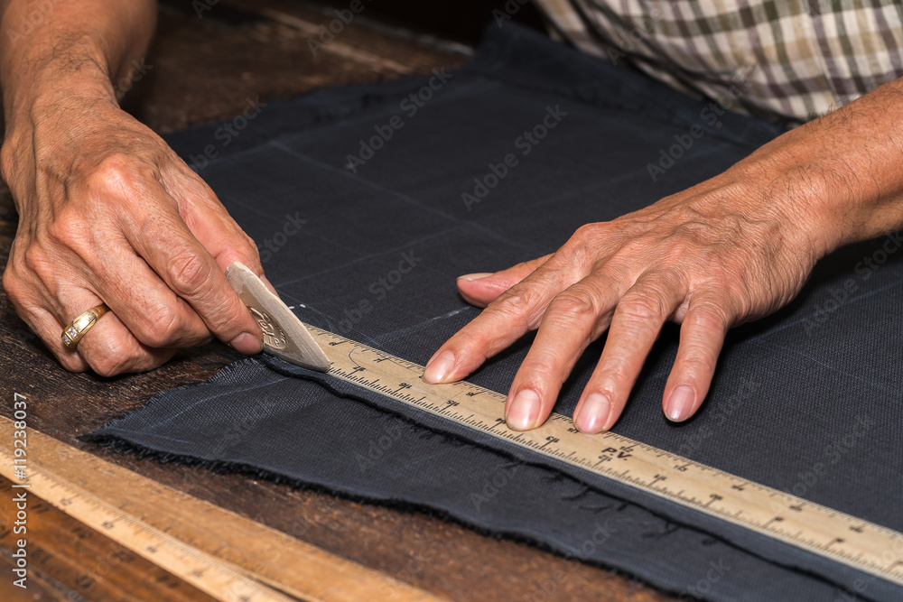 Tailor at work, drawing line on fabric with chalk
Tailor at work, drawing line on fabric with chalk