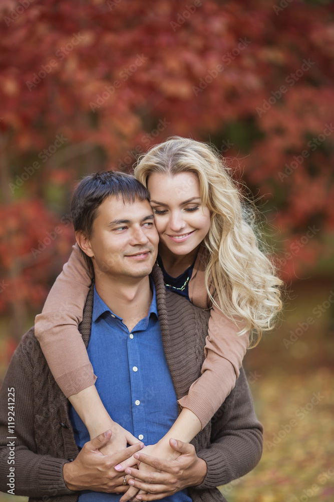 Happy smiling couple in a park in the autumn Happy smiling couple in a park in the autumn