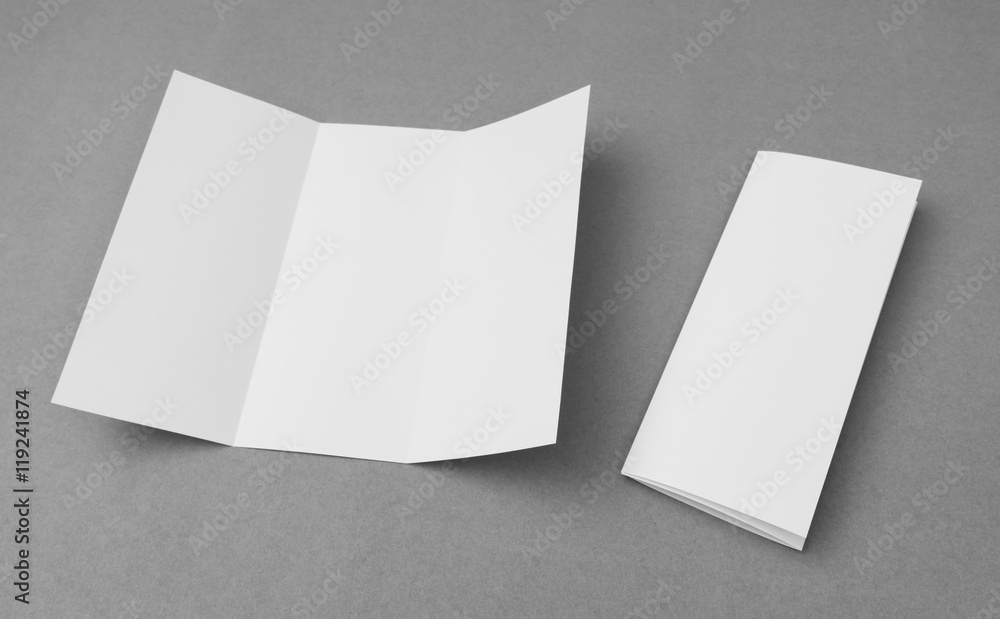 Trifold white template paper on gray background .