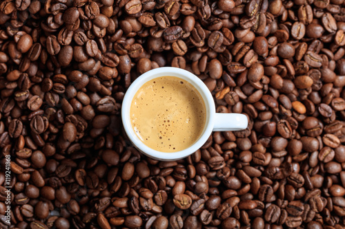 Cup of coffee on coffee beans background