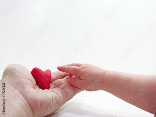Fototapeta Naklejka Na Ścianę i Meble -  Man's and child hands with red heart