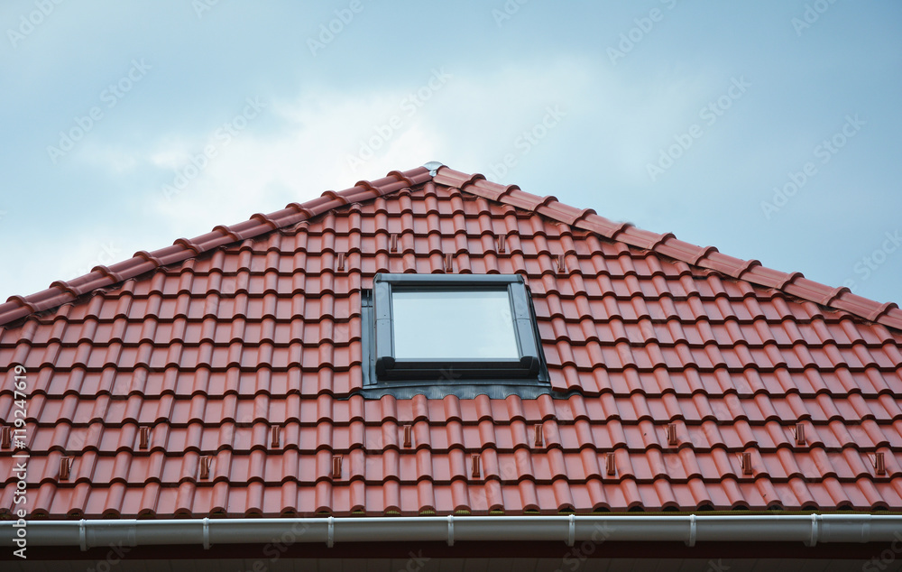 Close up on house roof window, sun tunnel skylights or skylight after rain on red ceramic tiles roof. Attic skylight solution outdoor.