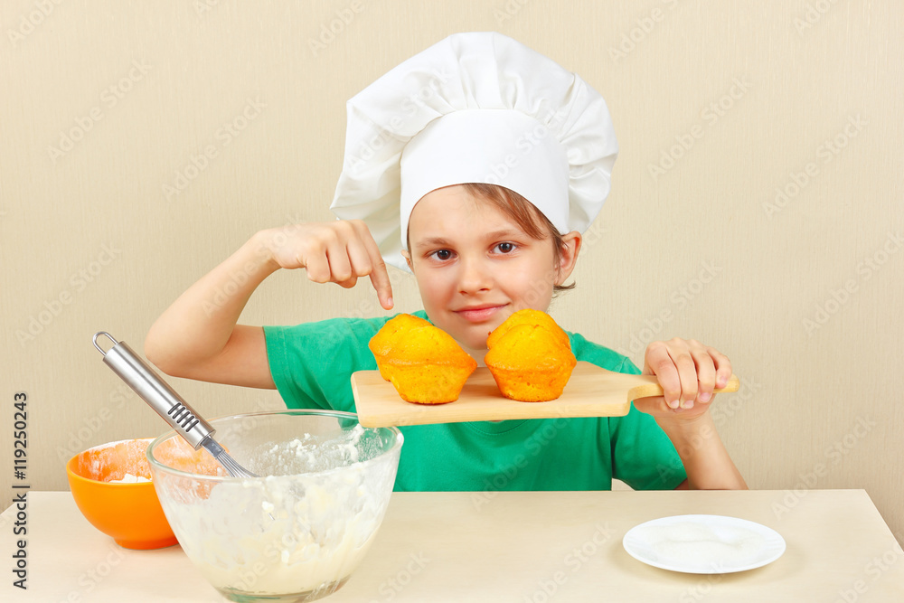 Young funny boy in chefs hat with a cooked the appetizing cake Young funny boy in chefs hat with a cooked the appetizing cake