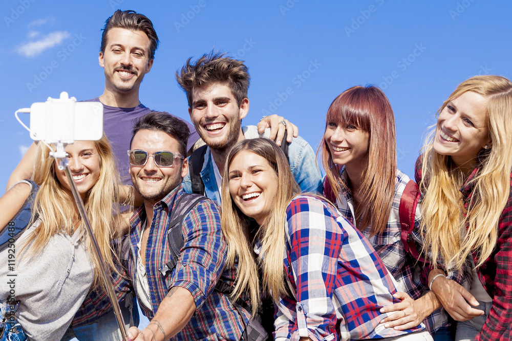 group of friends taking a self portrait with selfie stick group of friends taking a self portrait with selfie stick