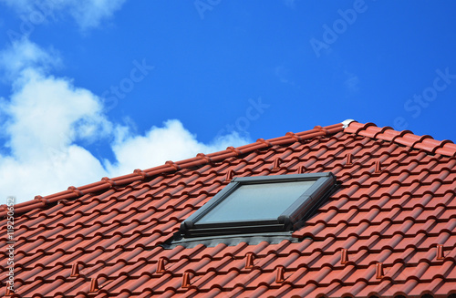 Skylight on red ceramic tiles house roof. Skylights, Roof Windows and Sun Tunnels.