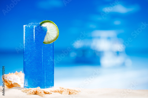 Tableau sur toile blue slush ice drink in glass with seascape