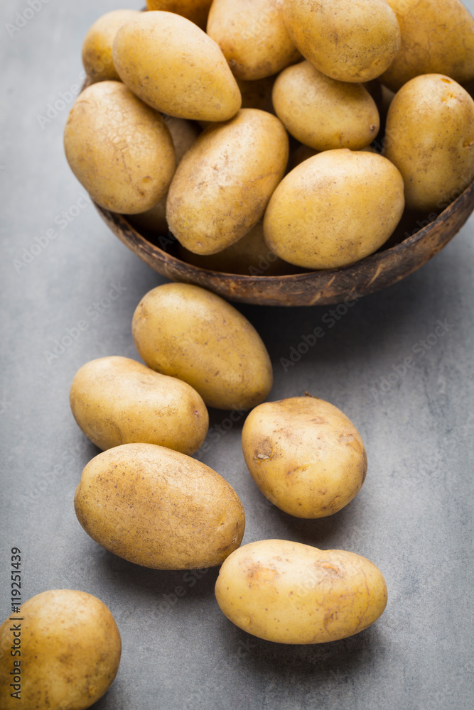 New potato on the bowl, gray background. New potato on the bowl, gray background.