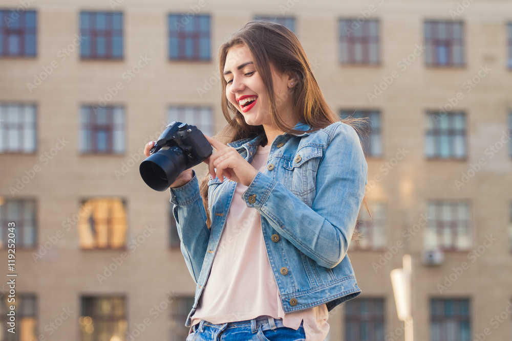 Young beautiful girl photographs . She is dressed in a denim suit . It portrait lens . Young beautiful girl photographs . She is dressed in a denim suit . It portrait lens .
