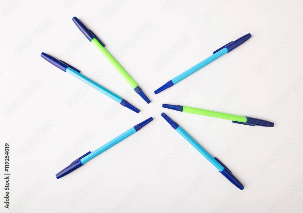 ballpoint pens of different colors on a white background