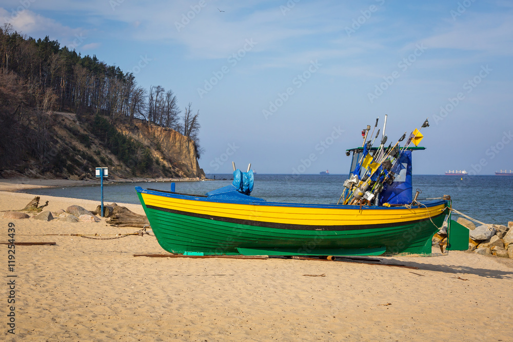 Naklejka premium Baltic beach with fishing boat at Orlowo cliff, Poland