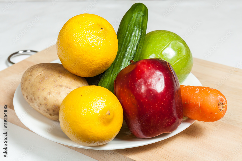 Plate of fruits and vegetables on chopping board Plate of fruits and vegetables on chopping board