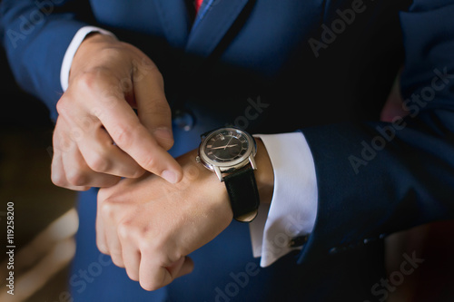Hands of wedding groom getting ready in suit