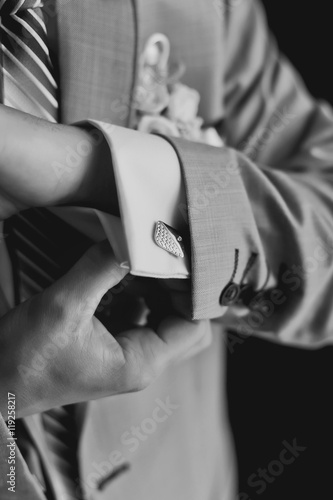 Fototapeta Naklejka Na Ścianę i Meble -  Hands of wedding groom getting ready in suit
