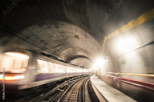 Fast underground train riding in a tunnel of the modern city