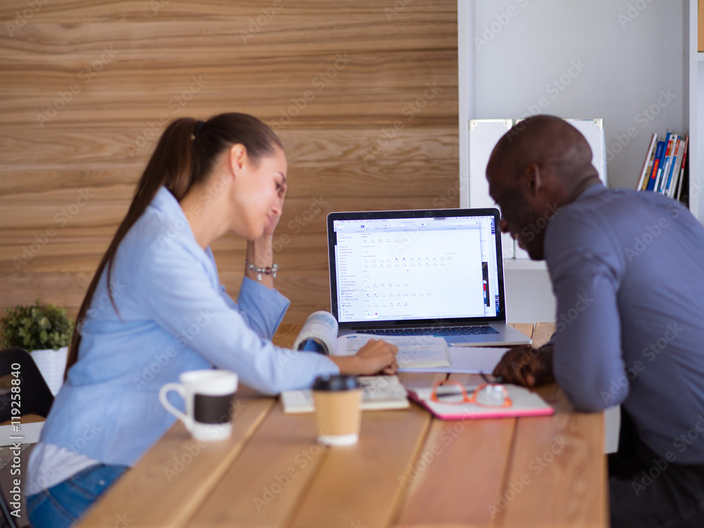 Attractive woman sitting at desk in office, working with laptop , having takeaway coffee. Attractive woman sitting at desk in office, working with laptop , having takeaway coffee.