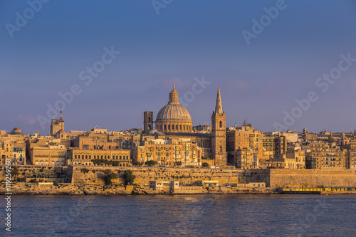 Valletta, Malta - The beautiful St.Paul's Cathedral and the ancient city of Valletta at sunset with clear blue sky