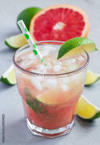 Cold pink cocktail with fresh grapefruit, lime and ice, vertical