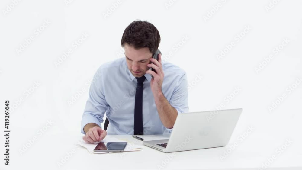 Businessman using laptop,talking on phone and smiling Businessman using laptop,talking on phone and smiling