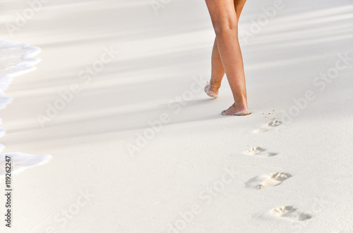 woman beachwalk with footprints