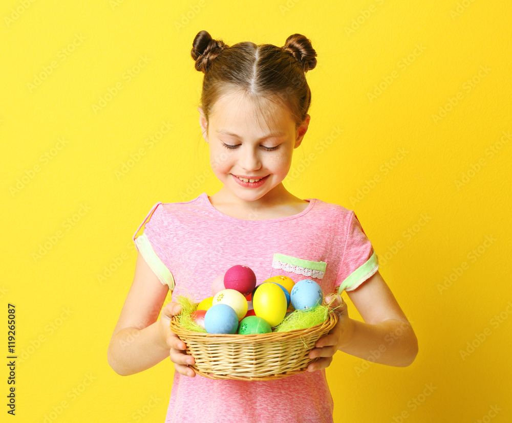 Cute girl with Easter eggs on yellow background Cute girl with Easter eggs on yellow background