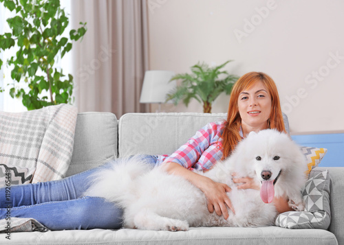 Girl with Samoyed dog on couch