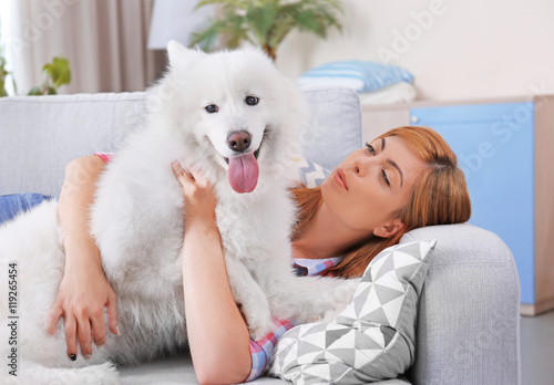 Girl with Samoyed dog on couch