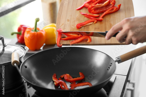 Photos Male hands putting red pepper in pan closeup