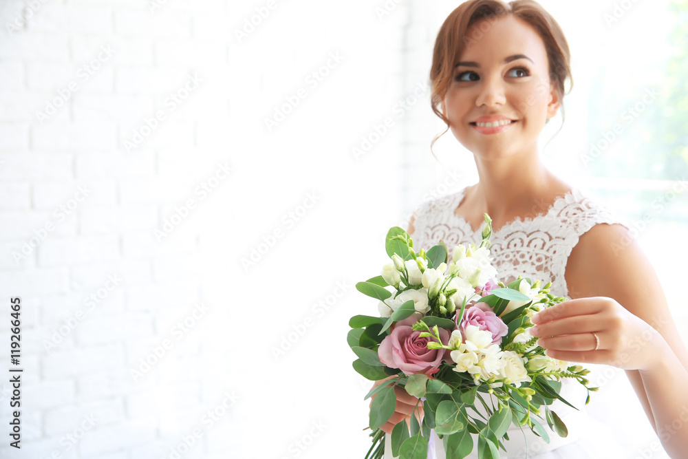 Beautiful bride with wedding bouquet on white brick wall background Beautiful bride with wedding bouquet on white brick wall background