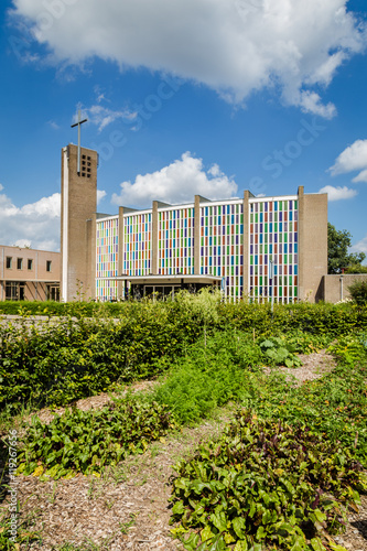 Urban agriculture: a vegetable garden beside a church building in the suburbs of a city photo